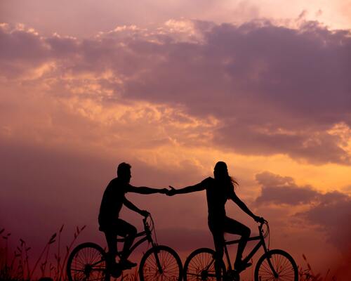 Happy couple riding bikes in the sunset