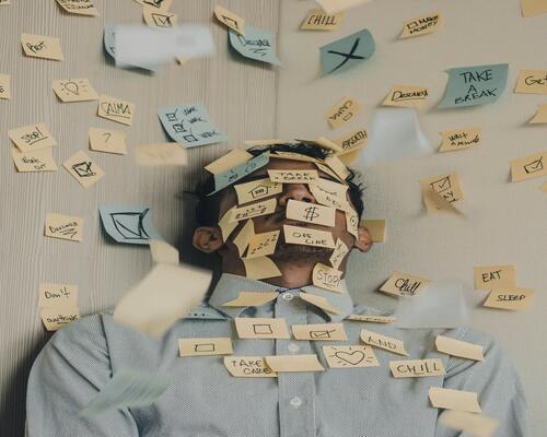 A guy with sticky notes feeling stressed